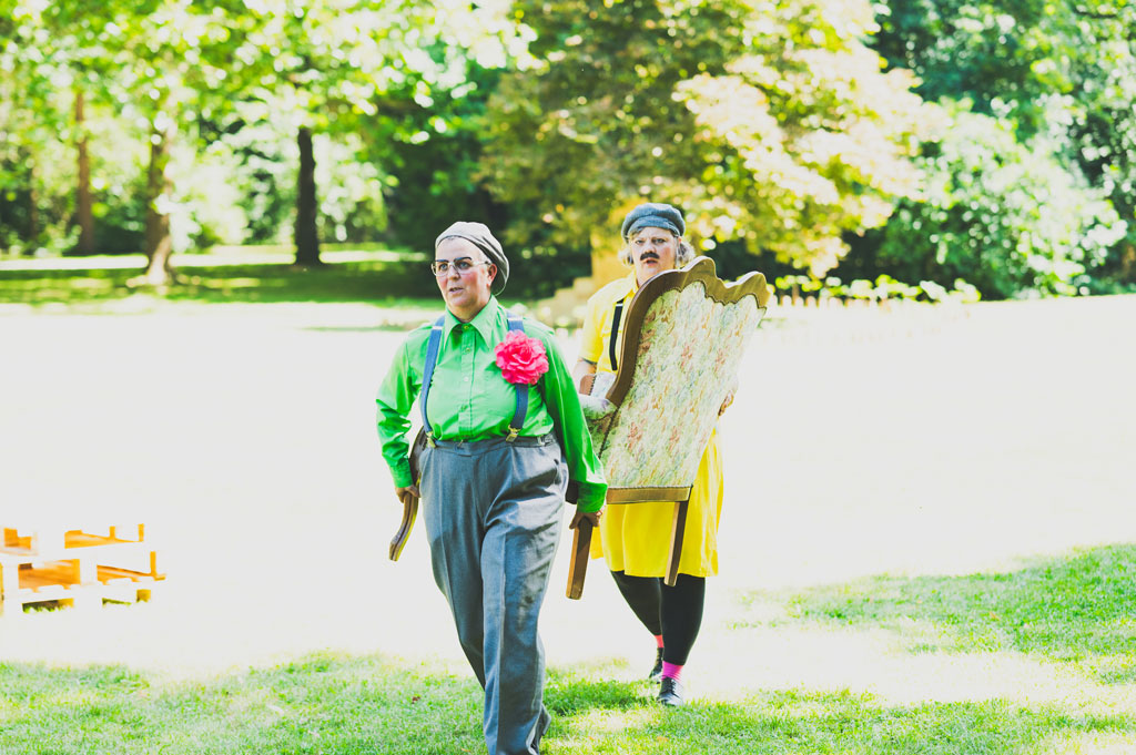 Walking Act CHARLY UND CHARLIE tragen ein Sofa durch den Park